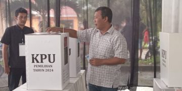 Romi Hariyanto memasukan surat suara kedalam kotak suara