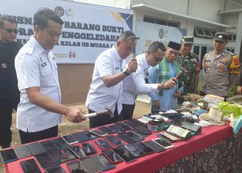 Kakanwil Ditjenpas Jambi Irwan Rahmat Gumilar menghancurkan Handphone dengan cara dipukul dengan palu