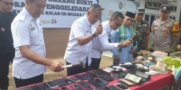 Kakanwil Ditjenpas Jambi Irwan Rahmat Gumilar menghancurkan Handphone dengan cara dipukul dengan palu