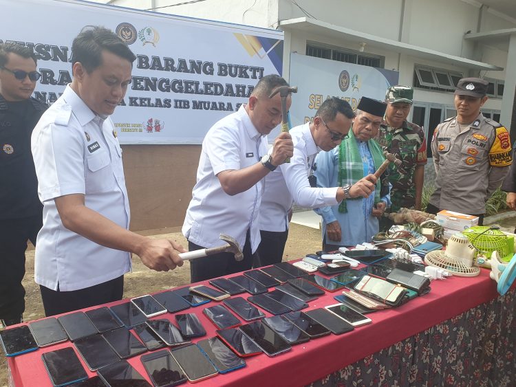 Kakanwil Ditjenpas Jambi Irwan Rahmat Gumilar menghancurkan Handphone dengan cara dipukul dengan palu