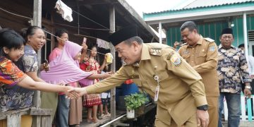 BEDAH RUMAH : Gubernur Jambi Al Haris bersalaman dengan warga penerima bantuan bedah rumah di Tanjung Jabung Barat