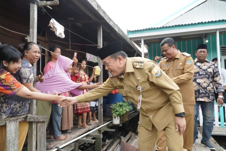 BEDAH RUMAH : Gubernur Jambi Al Haris bersalaman dengan warga penerima bantuan bedah rumah di Tanjung Jabung Barat