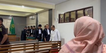 DAKWAAN : Terdakwa saat keluar ruangan sidang usai mendengarkan dakwaan penuntut umum