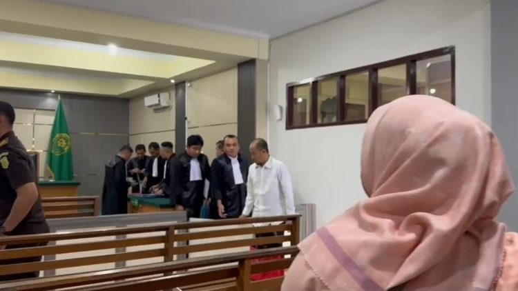 DAKWAAN : Terdakwa saat keluar ruangan sidang usai mendengarkan dakwaan penuntut umum