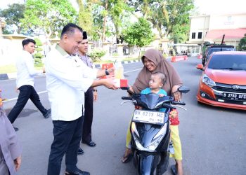 BAGI TAKJIL :Direktur reserse kriminal khusus Polda Jambi Kombes Pol Taufik Nurmandia  membagikan paket takjil kepada pengendara dan masyarakat yang melintas di Lapangan Mapolda Jambi