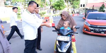 BAGI TAKJIL :Direktur reserse kriminal khusus Polda Jambi Kombes Pol Taufik Nurmandia  membagikan paket takjil kepada pengendara dan masyarakat yang melintas di Lapangan Mapolda Jambi
