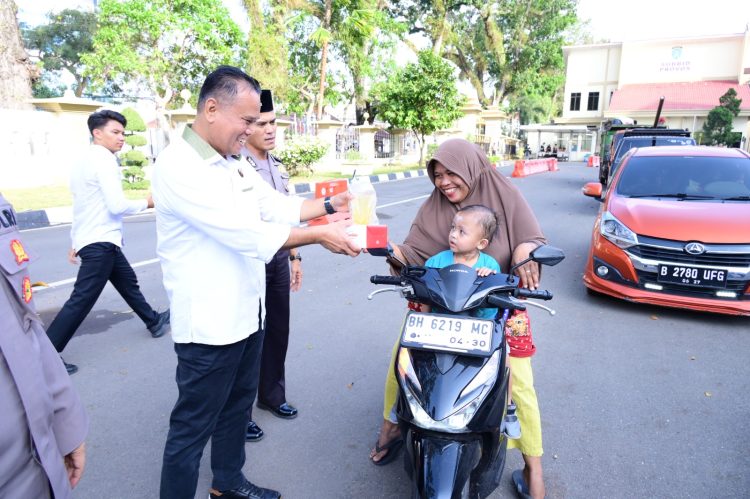 BAGI TAKJIL :Direktur reserse kriminal khusus Polda Jambi Kombes Pol Taufik Nurmandia membagikan paket takjil kepada pengendara dan masyarakat yang melintas di Lapangan Mapolda Jambi