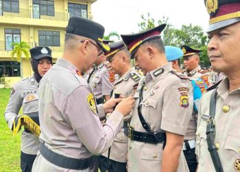 SERTIJAB : Kapolres Bungo AKBP Zamri Elfino, S.IK menyematkan tanda jabatan kepada pejabat yang baru dilantik dalam prosesi serah terima jabatan di halaman Mapolres Bungo