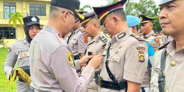 SERTIJAB : Kapolres Bungo AKBP Zamri Elfino, S.IK menyematkan tanda jabatan kepada pejabat yang baru dilantik dalam prosesi serah terima jabatan di halaman Mapolres Bungo
