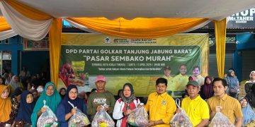 PASAR MUARAH : Ketua DPD Golkar Tanjab Barat, Syufrayogi Syaiful, menyerahkan paket sembako kepada warga dalam kegiatan pasar murah di Kuala Tungkal