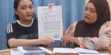 Keluarga Aji menunjukkan surat tanda bukti penerimaan pengaduan di Polda Jambi terkait dugaan fitnah dan pencemaran nama baik melalui media sosial