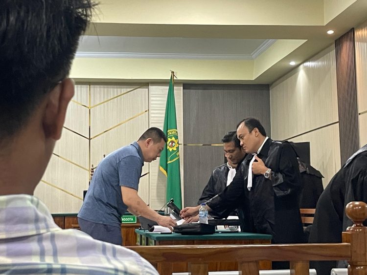 PEMBELAAN : Bengawan Kamto sedang berdiskusi dengan tim penasihat hukum terkaiat pembelaaan terdakwa
