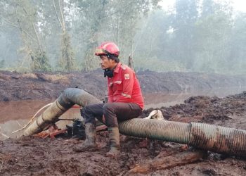 Aryanto Aritonang tengah beristirahat usai berjuang memadamkan lautaun api