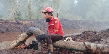 Aryanto Aritonang tengah beristirahat usai berjuang memadamkan lautaun api