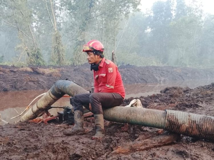 Aryanto Aritonang tengah beristirahat usai berjuang memadamkan lautaun api